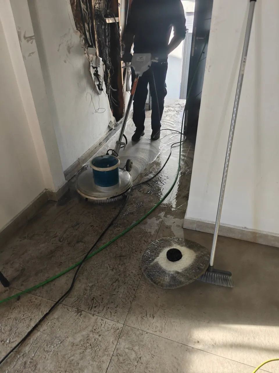 Monodisco limpiando hollín en suelo porcelánico de una vivienda en Móstoles tras incendio eléctrico